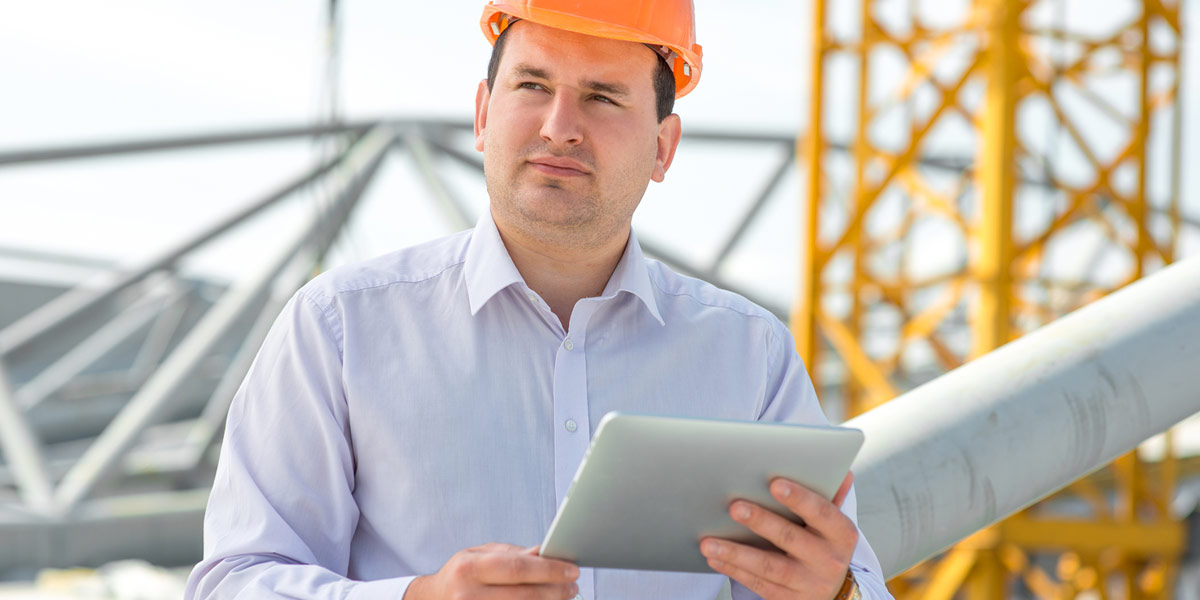 Man in hardhat doing clean energy audit on a commercial building