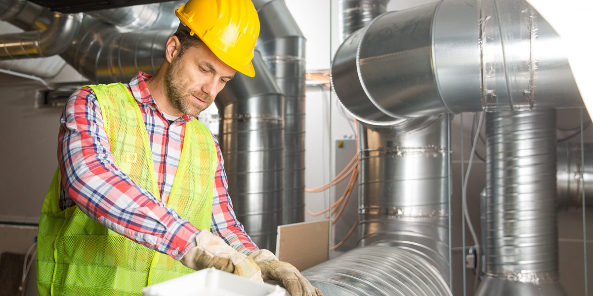 Man in hardhat doing an energy audit on commercial hvac